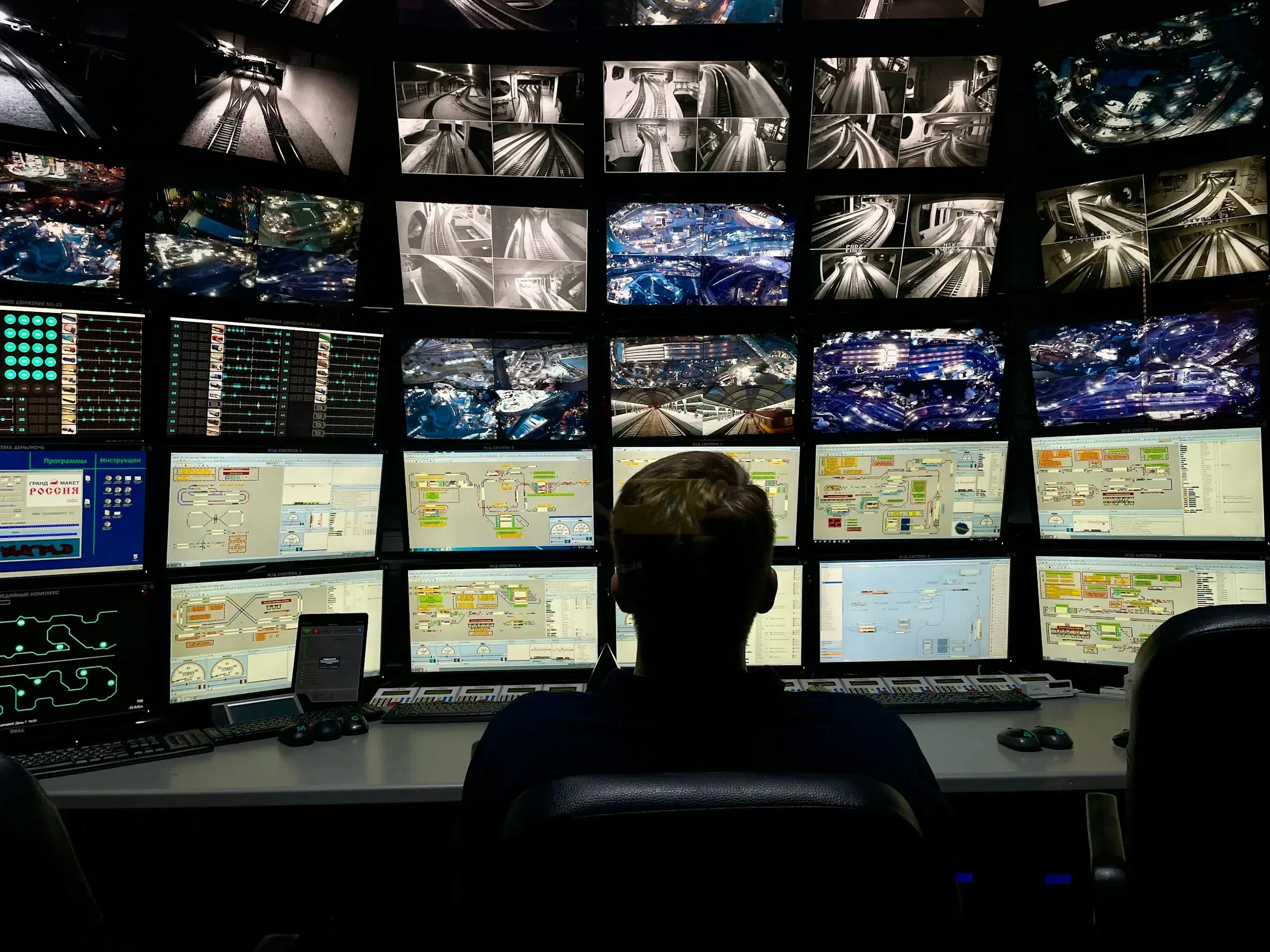 An operator in front of a wall of live operational screens