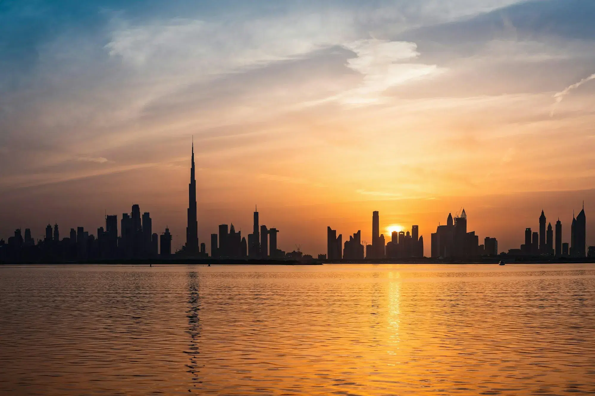 The Dubai skyline at sunset across the water
